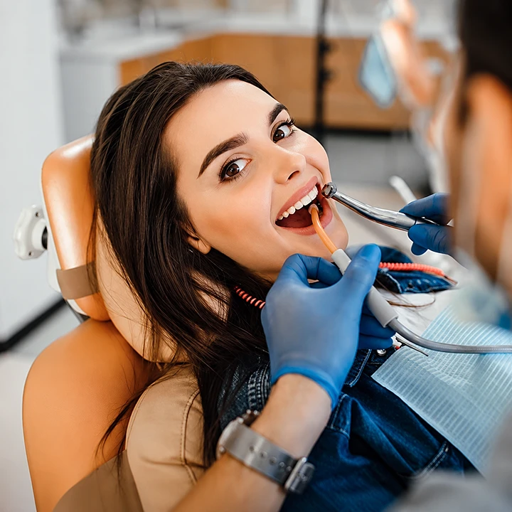 Dra. Alice examinando os dentes de uma paciente durante atendimento odontológico