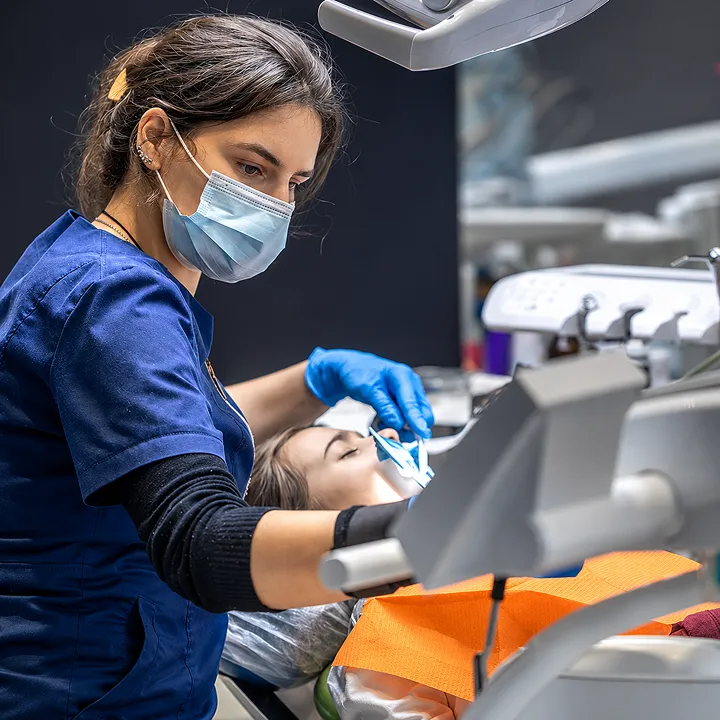 Dra. Alice examinando os dentes de uma paciente durante atendimento odontológico